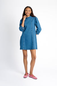 Model is wearing an A-Line mini denim dress with red check shoes