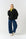 Model is wering a black sweatshirt with a v neck detail, with a lime polo neck and blue denim jeans