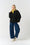 Model is wering a black sweatshirt with a v neck detail, with a lime polo neck and blue denim jeans