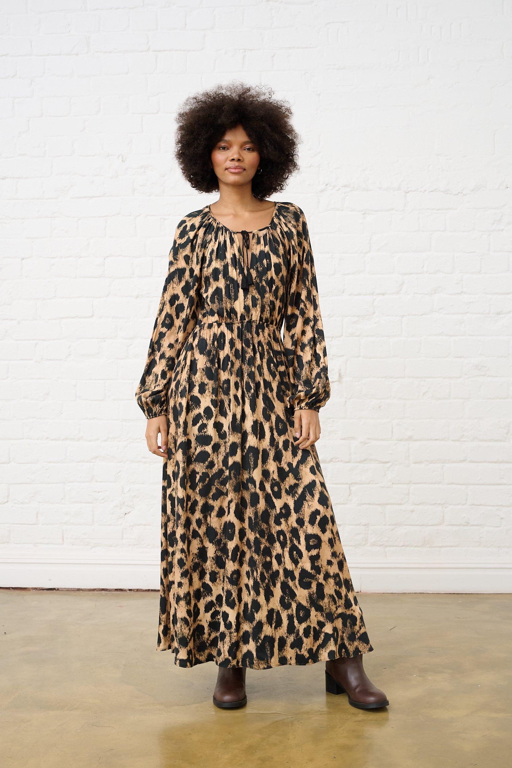 Modle is wearing a women's animal print maxi dress with long sleeves and relaxed fit