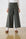 Model is wearing wide leg olive bengaline pants with contrast stitching and brown shoes 
