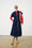 Model is wearing a denim dress with brown boots and red accessories 
