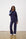 Model is wearing a navy knit sweat set with white sneakers and sunglasses