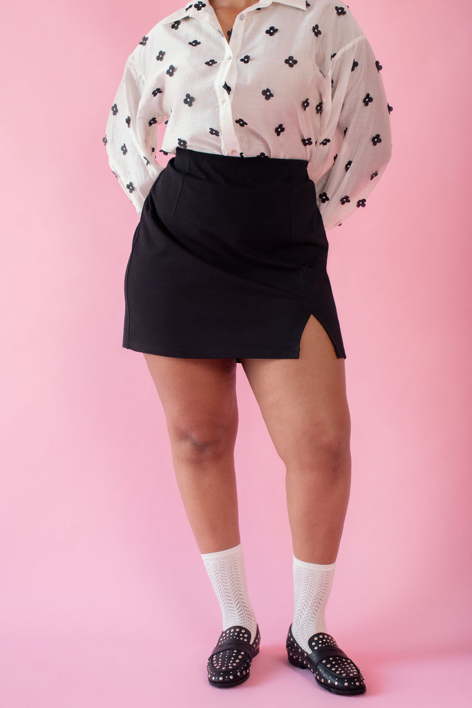 Model wearing mini black skirt 