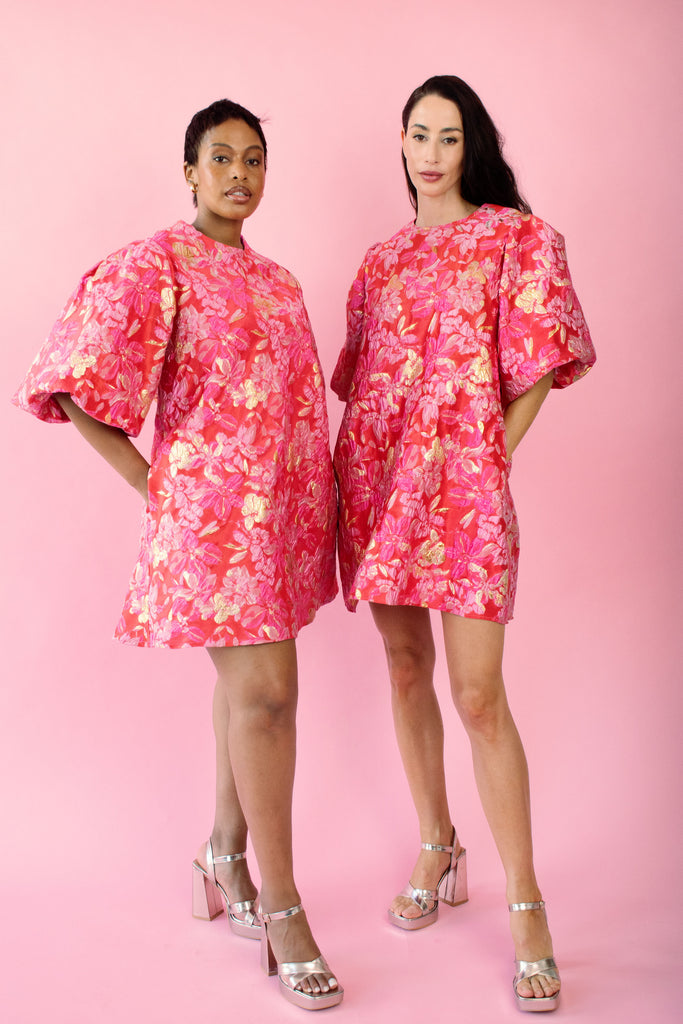 Models wearing red and pink brocade dress