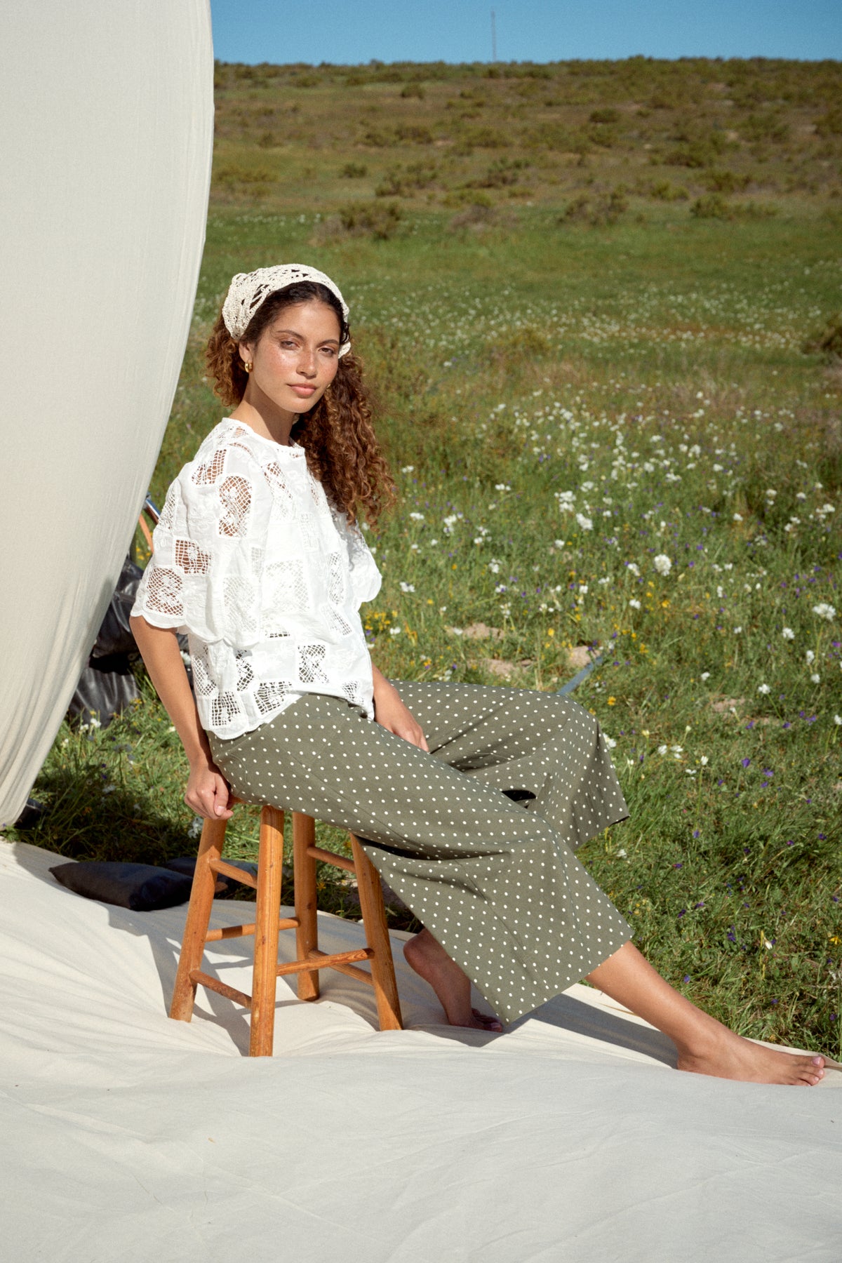 Model wearing milk white lace tee with scalloped sleeves and hem