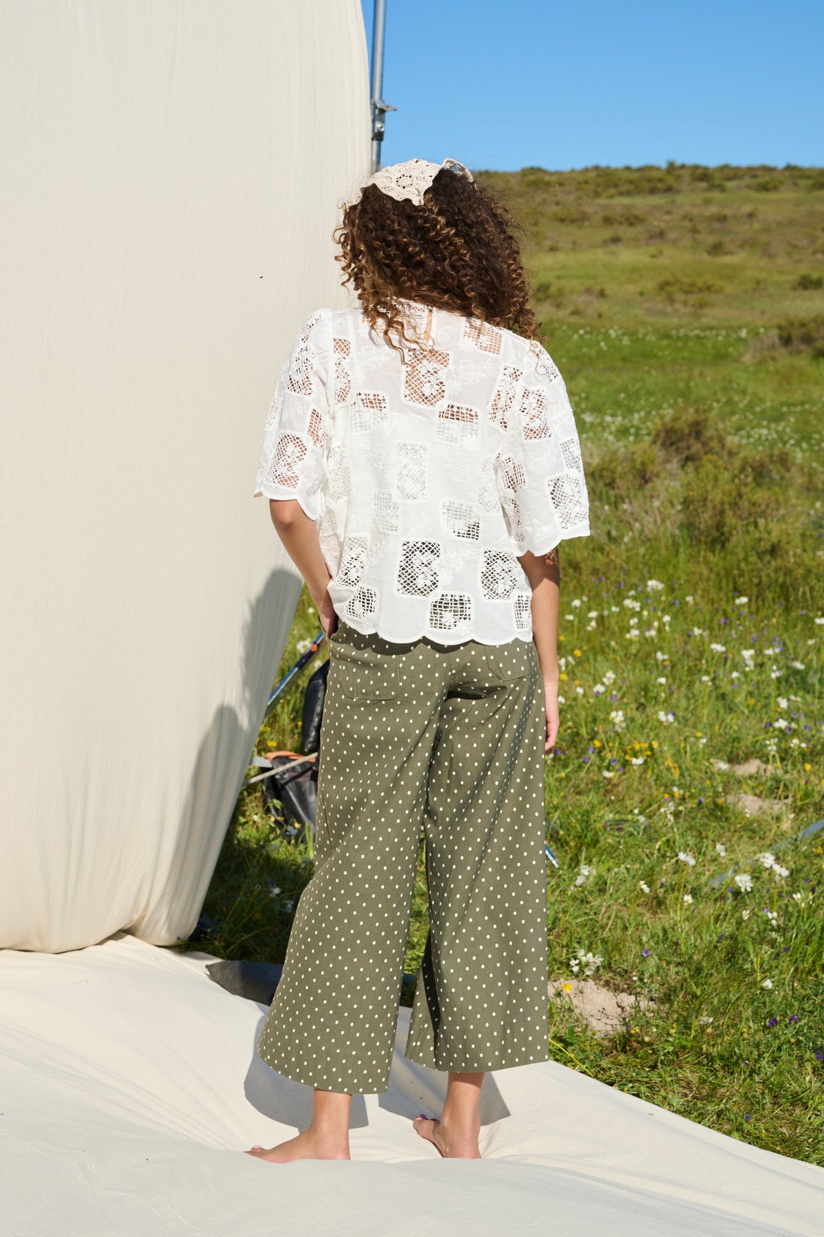 Model wearing milk white lace tee with scalloped sleeves and hem