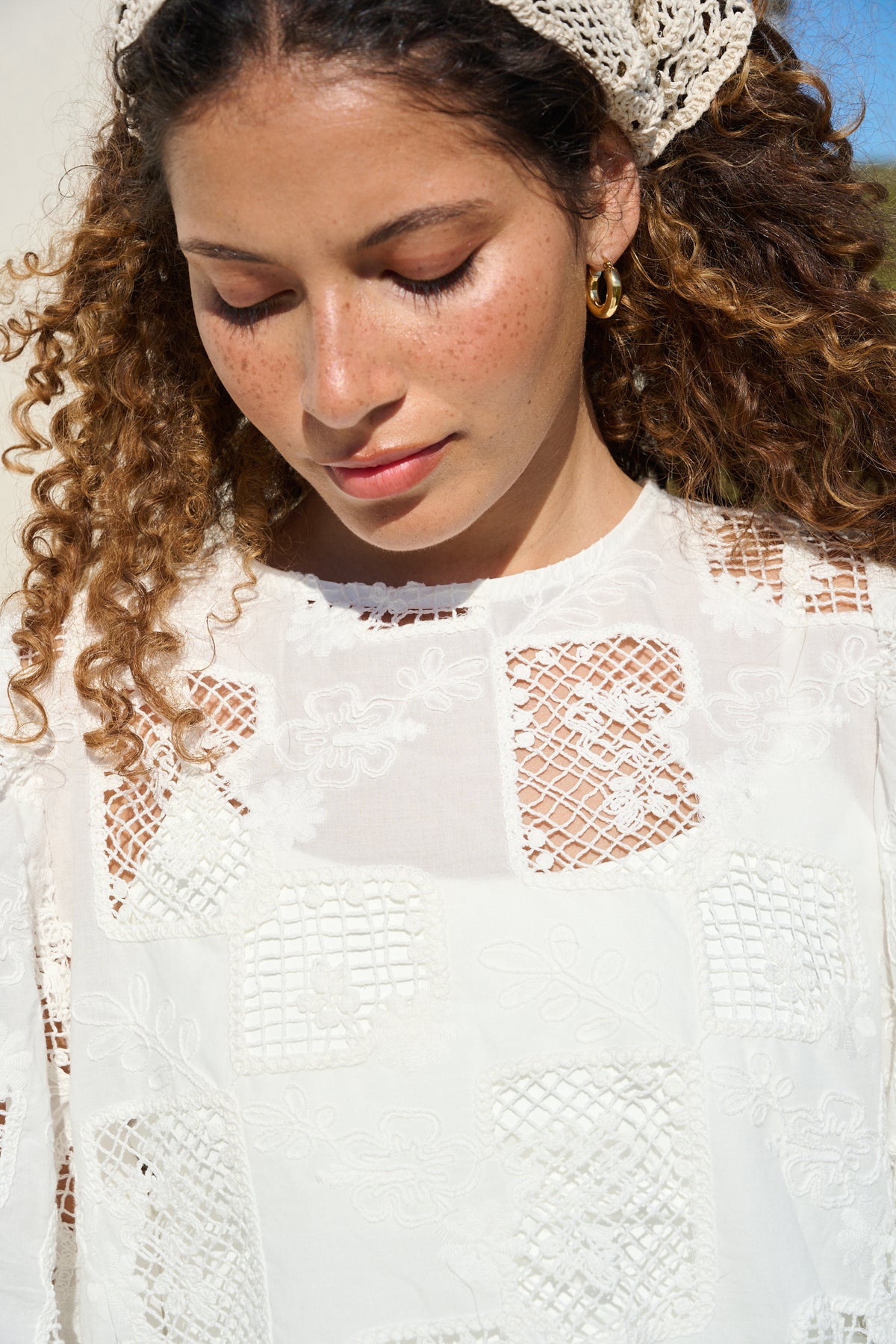 Model wearing milk white lace tee with scalloped sleeves and hem