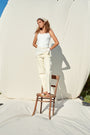 Model wearing light banana yellow jeans with lace on side seams