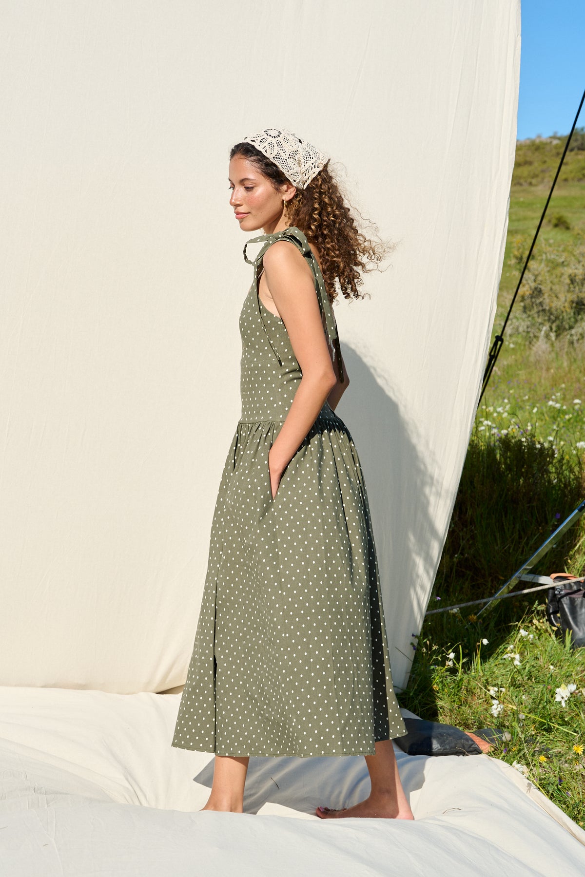 Model wearing fatigue green polka dot midi dress with tie straps