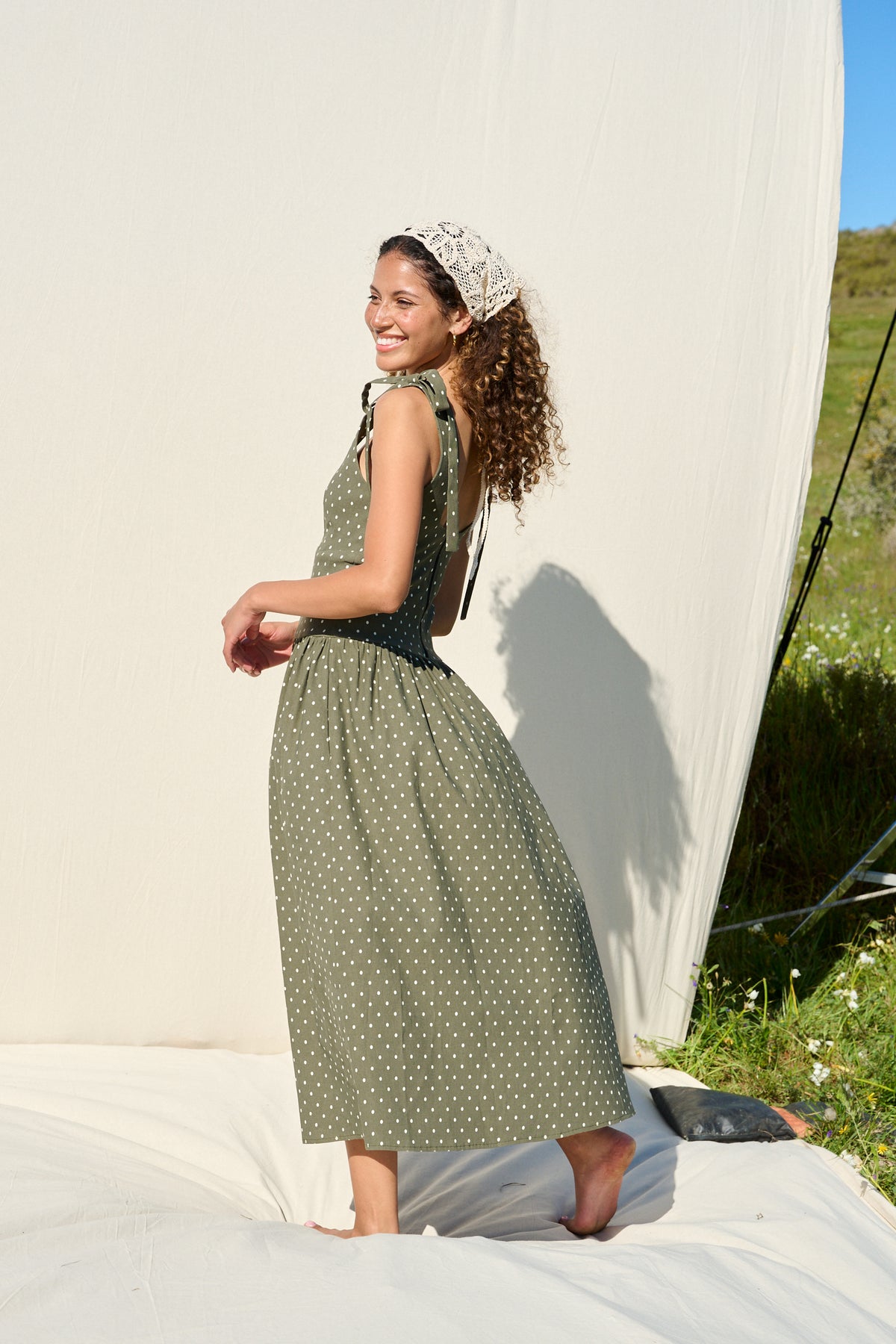 Model wearing fatigue green polka dot midi dress with tie straps
