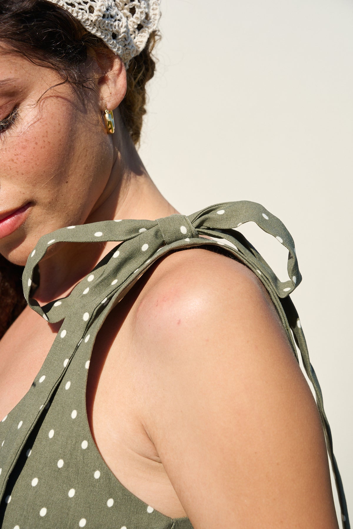 Model wearing fatigue green polka dot midi dress with tie straps