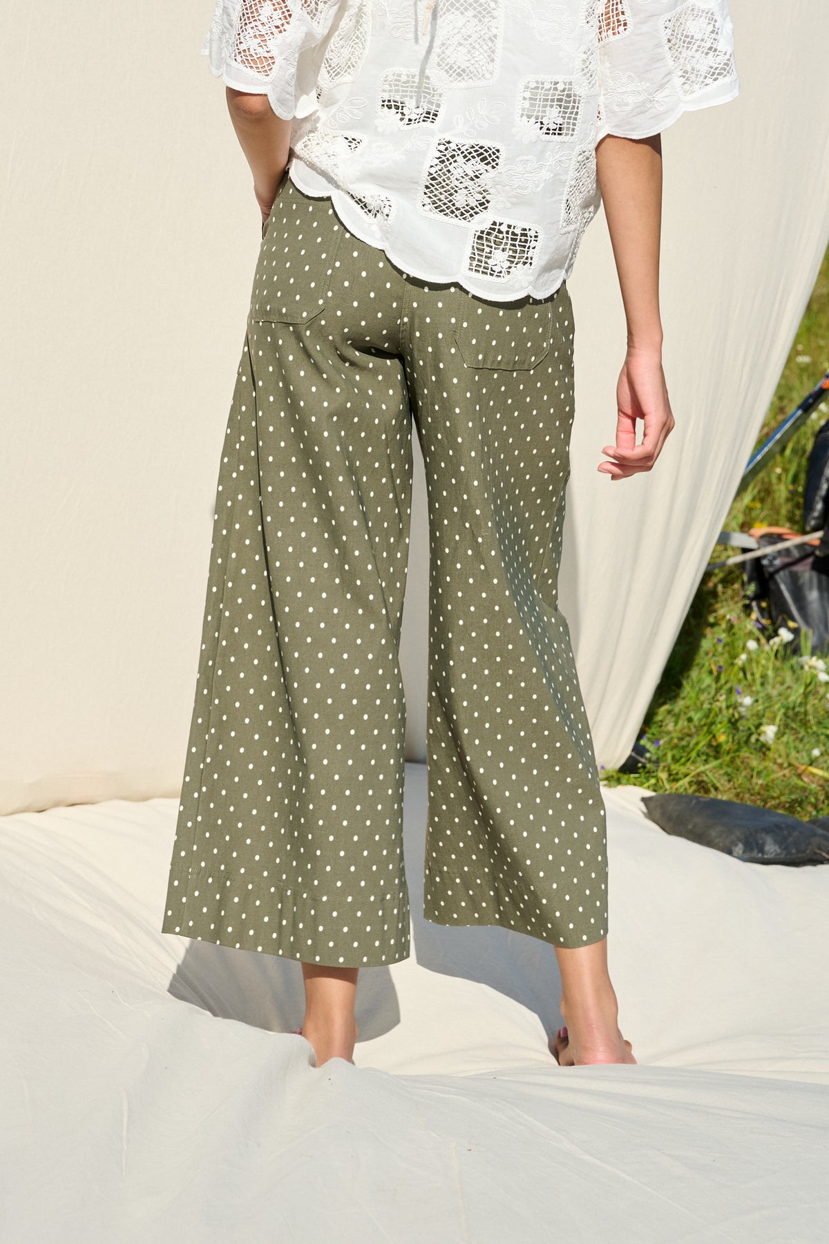 Model wearing fatigue green polka dot wide-leg pants with patch pockets