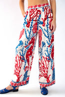 Model wearing sea horse printed pants with blue sandals