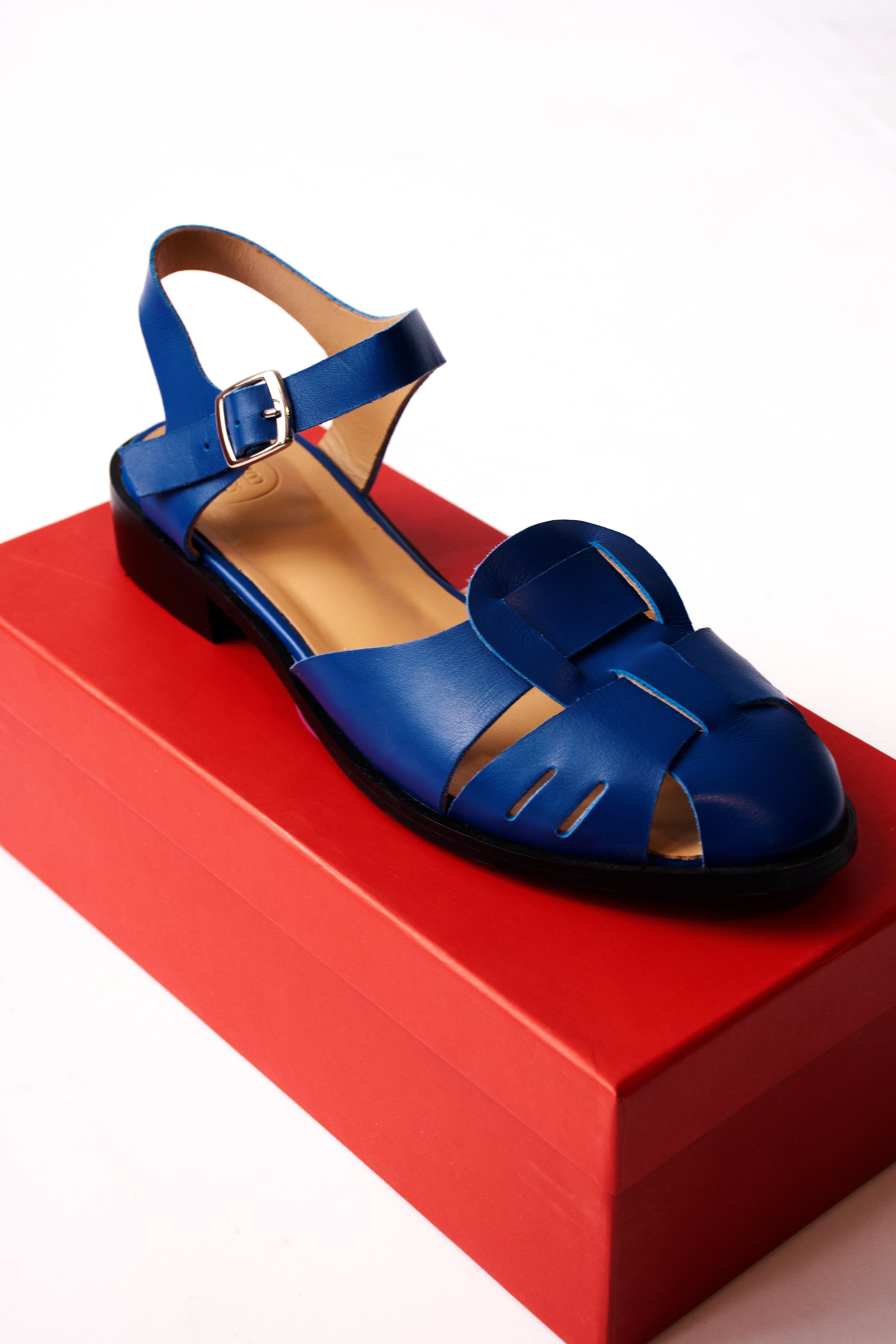 Blue caged sandal on red show box
