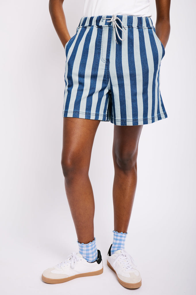 Model is wearing short, striped, blue denim shorts with a drawstring waist.