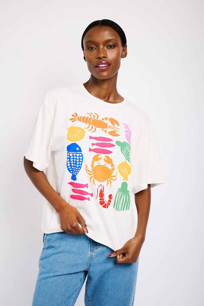 Model is wearing an oversized white T-shirt with a big statement print.