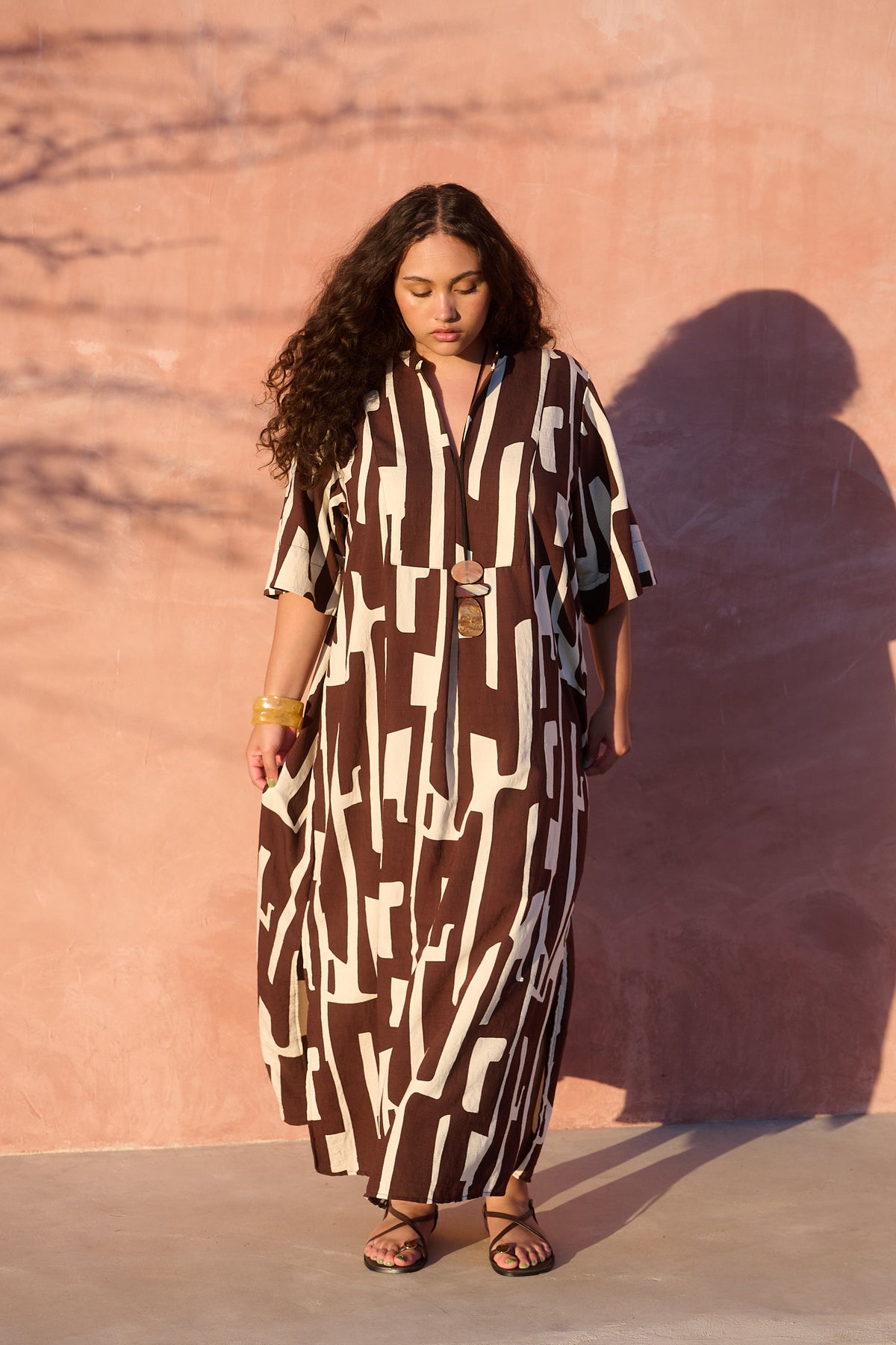 Model wearing chocolate banana-print rayon bib-front maxi tunic