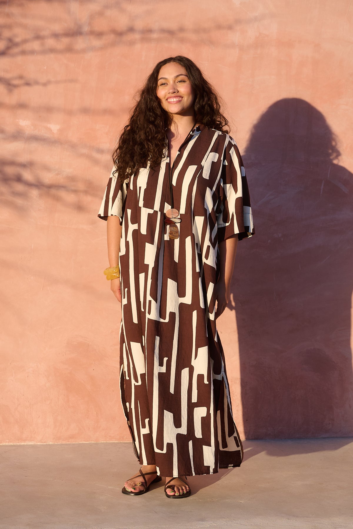 Model wearing chocolate banana-print rayon bib-front maxi tunic