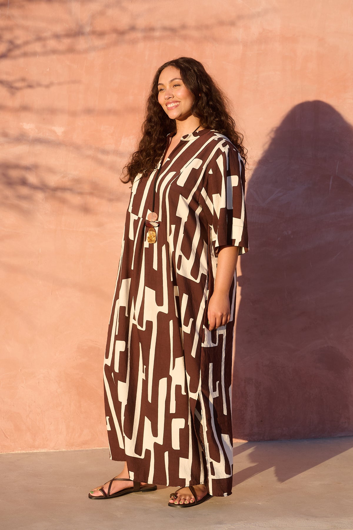Model wearing chocolate banana-print rayon bib-front maxi tunic