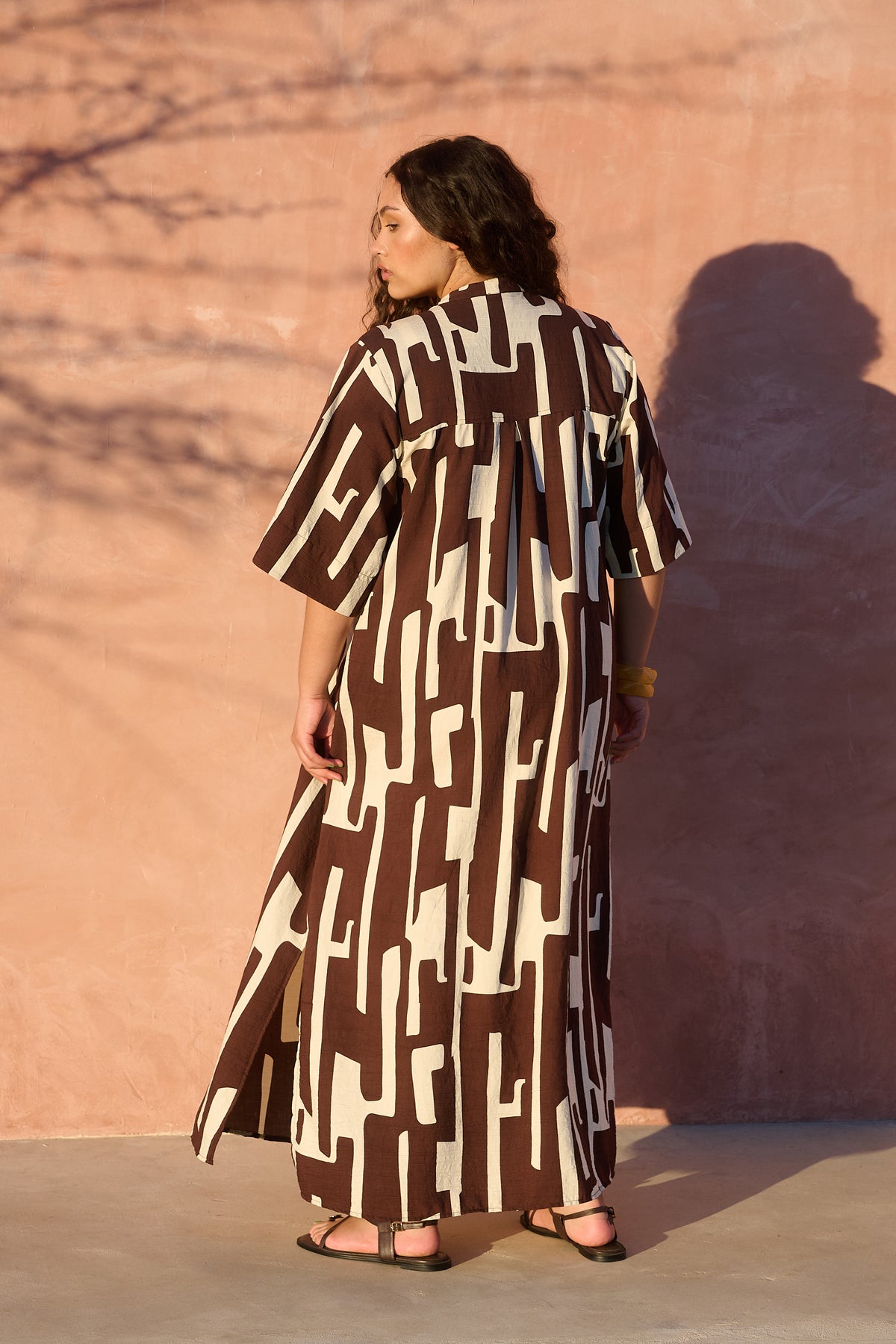 Model wearing chocolate banana-print rayon bib-front maxi tunic