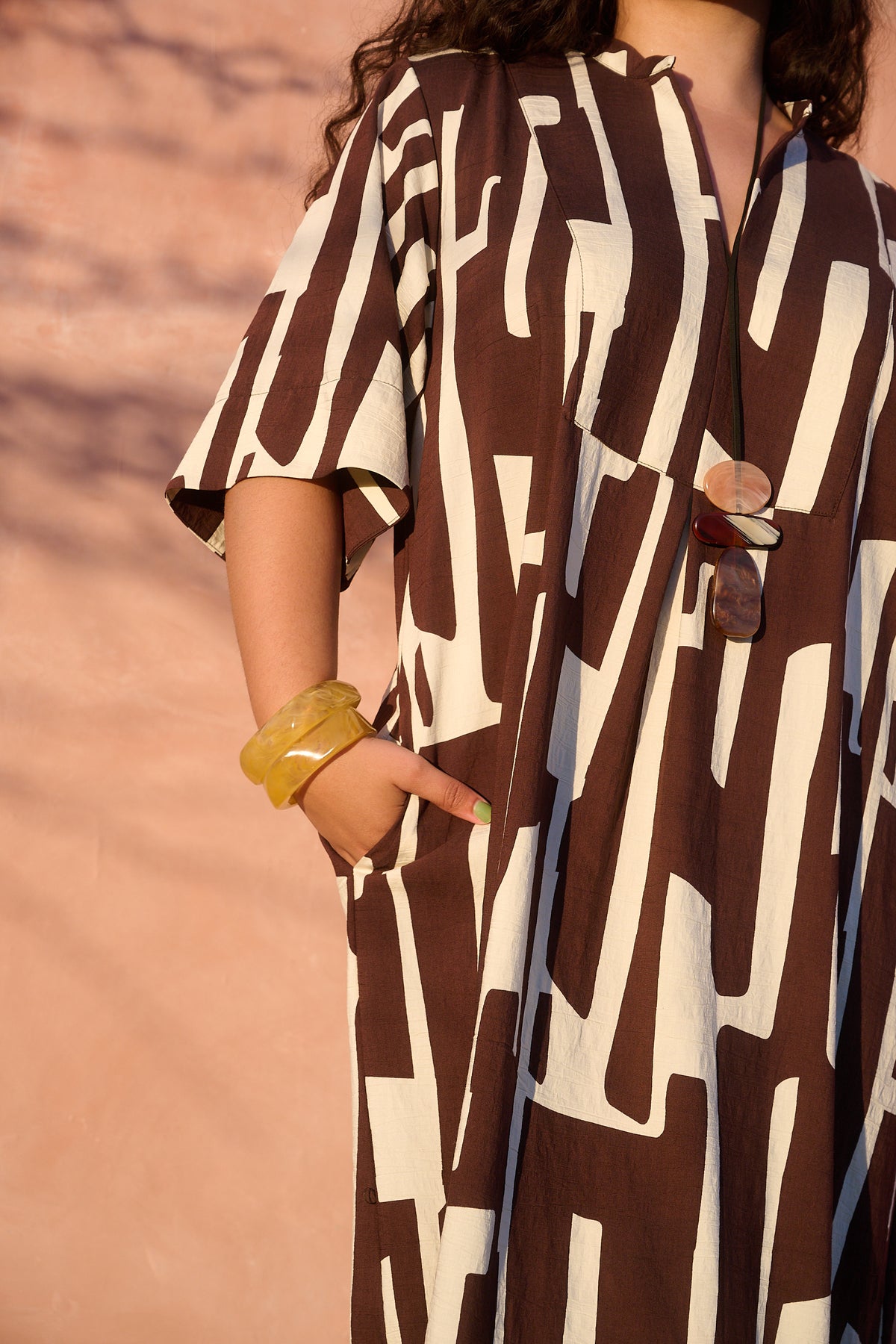 Model wearing chocolate banana-print rayon bib-front maxi tunic