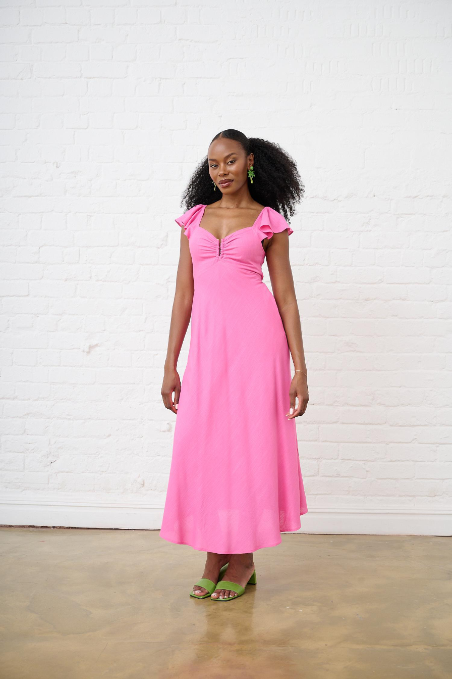 MODEL IS WEARING A PINK DRESS WITH GREEN SHOES 