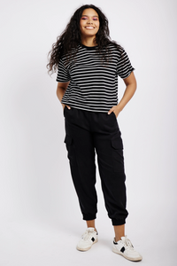 Model wearing black tencel tapered leg cargo pants, stripe T-shirt and white sneakers